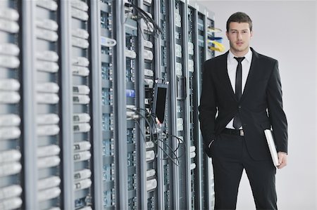 suit on rack - young engeneer business man with thin modern aluminium laptop in network server room Stock Photo - Budget Royalty-Free & Subscription, Code: 400-05291409