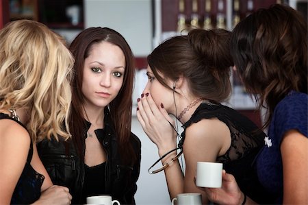In a group of four cute girls, a friend whispers something to another in a cafe Stock Photo - Budget Royalty-Free & Subscription, Code: 400-05291773