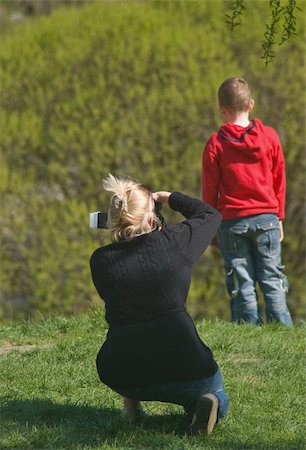 documentario - Woman from back photographing her son Fotografie stock - Microstock e Abbonamento, Codice: 400-05292657