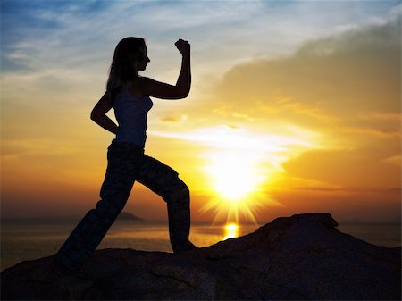 Silhouette of woman doin training exercise at sunrise time Stock Photo - Budget Royalty-Free & Subscription, Code: 400-05293025