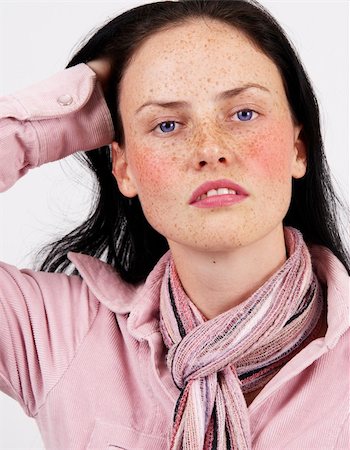 simsearch:400-04974367,k - Portrait of a beautiful brunette woman with light blue eyes and freckles on her skin, wearing pink winter jacket and colorful scarf Photographie de stock - Aubaine LD & Abonnement, Code: 400-05304396