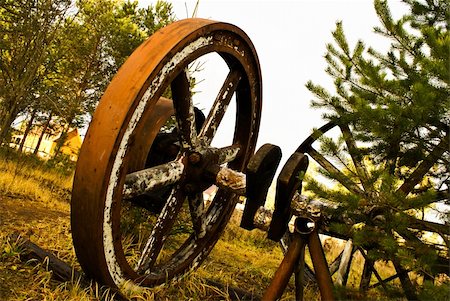 simsearch:400-04872609,k - Old wooden wheel standing with grass & trees background Fotografie stock - Microstock e Abbonamento, Codice: 400-05304614
