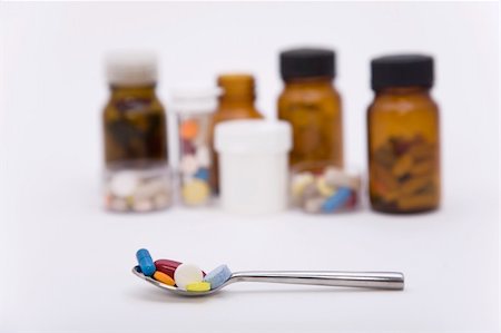 differently colored pills in spoon with other pills on the background Stock Photo - Budget Royalty-Free & Subscription, Code: 400-05304929