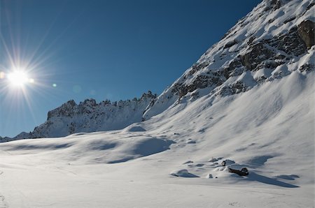 Dolomites mountain range detail from the Marmolada area. Sun with flares. Clear blue sky. Photographie de stock - Aubaine LD & Abonnement, Code: 400-05305092