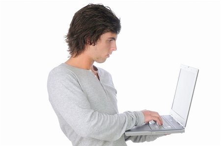 Handsome young man isolated over white on computer Stock Photo - Budget Royalty-Free & Subscription, Code: 400-05306377