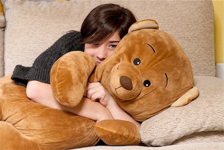 furry teddy bear - Young woman embracing teddy bear lying on on sofa close-up Stock Photo - Budget Royalty-Free & Subscription, Code: 400-05308178