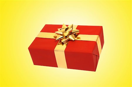 simsearch:400-05902598,k - Red christmas present box with gold bow and ribbons over yellow background Photographie de stock - Aubaine LD & Abonnement, Code: 400-05300332