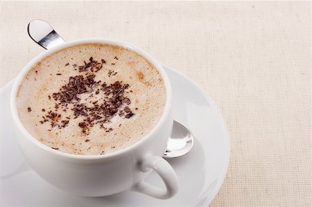 simsearch:400-04604628,k - Cappuccino in a white ceramic cup with a saucer and a spoon. Stockbilder - Microstock & Abonnement, Bildnummer: 400-05301370
