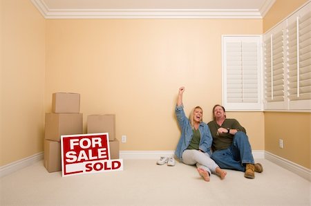 Excited Couple Relaxing on Floor Near Boxes and Sold Real Estate Signs in Empty Room. Stock Photo - Budget Royalty-Free & Subscription, Code: 400-05301752