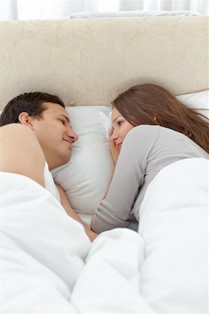 sleeping bed full body - Cute couple looking at each other while relaxing on the bed at home Stock Photo - Budget Royalty-Free & Subscription, Code: 400-05301815