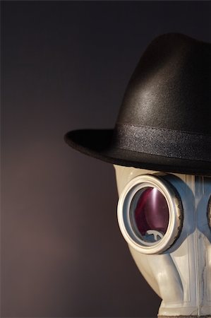 Gas mask with a felt hat closeup on dark background Stock Photo - Budget Royalty-Free & Subscription, Code: 400-05302591