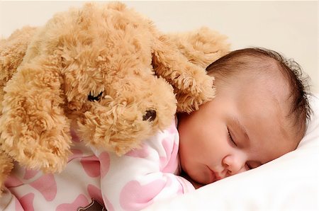 baby with white and pink sleepwear, sleeps with brown toy dog on her back Stockbilder - Microstock & Abonnement, Bildnummer: 400-05302724