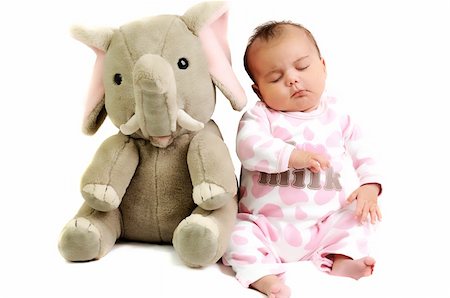baby girl with pink dots suite sitting and sleeping with grey elephant toy next to her Stockbilder - Microstock & Abonnement, Bildnummer: 400-05302726