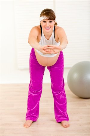 Smiling beautiful pregnant woman making gymnastics  at living room Stock Photo - Budget Royalty-Free & Subscription, Code: 400-05303069