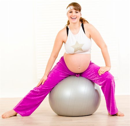 Smiling beautiful pregnant woman doing exercises on  fitness ball at living room Stock Photo - Budget Royalty-Free & Subscription, Code: 400-05303085