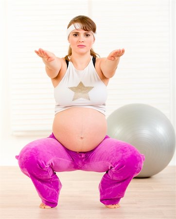 Smiling beautiful pregnant woman doing fitness exercises at living room Stock Photo - Budget Royalty-Free & Subscription, Code: 400-05303088
