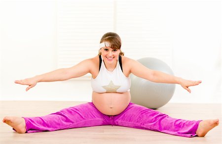 Smiling beautiful pregnant woman doing stretching exercises Stock Photo - Budget Royalty-Free & Subscription, Code: 400-05303094