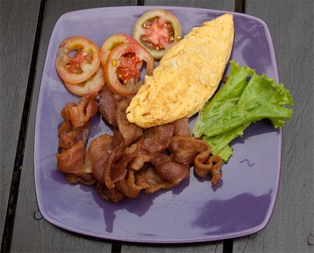 simsearch:400-04414187,k - Breakfast meal fried meat omelette and tomatoes on violet plate Photographie de stock - Aubaine LD & Abonnement, Code: 400-05303191