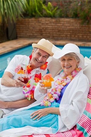 Mature couple drinking a cocktail  beside the swimming pool Stock Photo - Budget Royalty-Free & Subscription, Code: 400-05314415