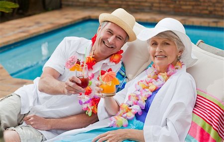 Mature couple drinking a cocktail  beside the swimming pool Stock Photo - Budget Royalty-Free & Subscription, Code: 400-05314416