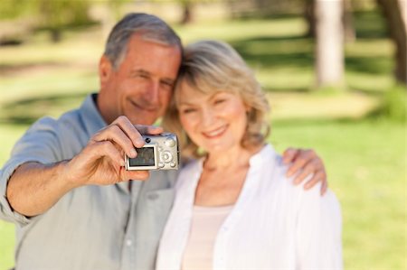 Elderly couple taking a photo of themselves in the park Stock Photo - Budget Royalty-Free & Subscription, Code: 400-05315017