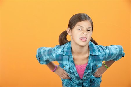 Little Hispanic girl with hands on hips sticks out her tongue Foto de stock - Super Valor sin royalties y Suscripción, Código: 400-05315159