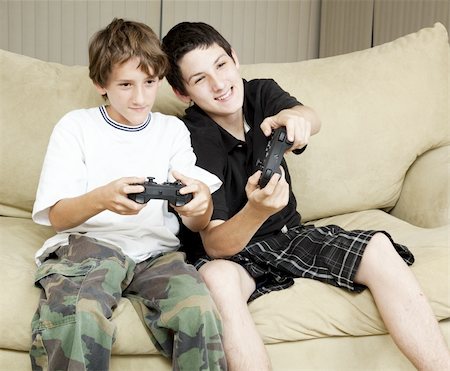 simsearch:400-05315413,k - Two brothers at home playing video games together. Fotografie stock - Microstock e Abbonamento, Codice: 400-05315408