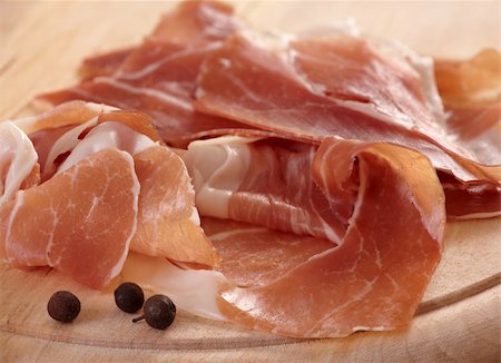 foodphoto (artist) - prosciutto slices and black pepper on wooden cutting board Fotografie stock - Microstock e Abbonamento, Codice: 400-05315422