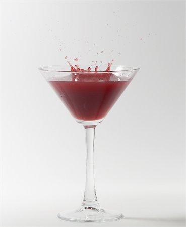 simsearch:400-06409646,k - red martini cocktail splashing into glass on white background Stock Photo - Budget Royalty-Free & Subscription, Code: 400-05315979