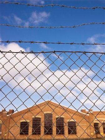 Brick Wall building behind a fence Stock Photo - Budget Royalty-Free & Subscription, Code: 400-05317276