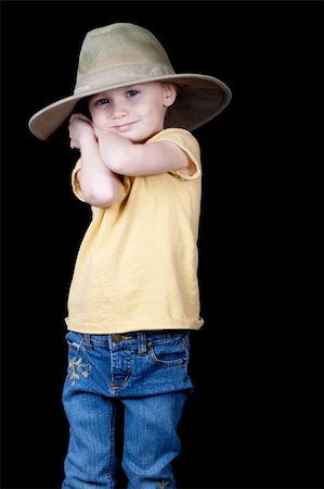 strotter13 (artist) - A girl with an oversized hat on.  Her arms and hands are clasped behind her head as if she is holding something back or hiding something. Photographie de stock - Aubaine LD & Abonnement, Code: 400-05317482