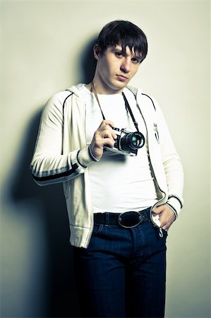 Photographer holding  the film camera on light background. Contrast image. Stock Photo - Budget Royalty-Free & Subscription, Code: 400-05319015