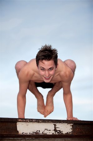 simsearch:400-04328141,k - Happy young man doing the Bakasana yoga posture Stock Photo - Budget Royalty-Free & Subscription, Code: 400-05319881
