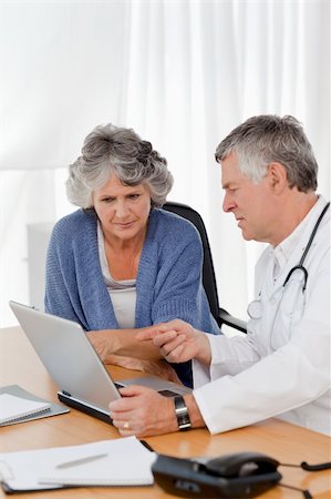 A senior doctor with his patient looking at the laptop in his office Stock Photo - Budget Royalty-Free & Subscription, Code: 400-05310709