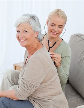 Nurse taking the heartbreat of her patient at home Stock Photo - Budget Royalty-Free & Subscription, Code: 400-05310726