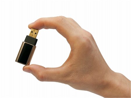 finger holding a key - Hand with flash memory on white background Photographie de stock - Aubaine LD & Abonnement, Code: 400-05312197