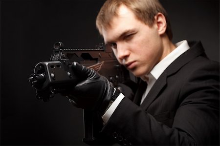 simsearch:400-04816325,k - Man with gun over gradient gray Stock Photo - Budget Royalty-Free & Subscription, Code: 400-05312286