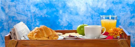 Delicious breakfast on tray consisting of coffee, orange juice, apple, croissants, jam and butter with newspaper lying on the side Fotografie stock - Microstock e Abbonamento, Codice: 400-05325762