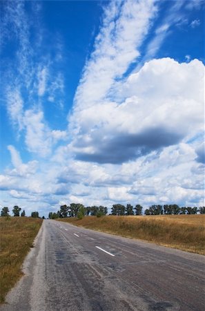 old asphalt road passes through farm fields Stock Photo - Budget Royalty-Free & Subscription, Code: 400-05325878