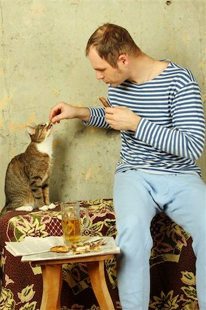 young man on the background side wall of concrete with a glass of beer next to the cat steals from him the fish Stock Photo - Budget Royalty-Free & Subscription, Code: 400-05328564