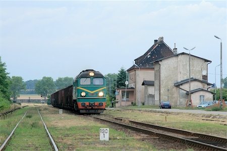 simsearch:400-07417657,k - Freight train hauled by diesel locomotive passing the station Fotografie stock - Microstock e Abbonamento, Codice: 400-05321068