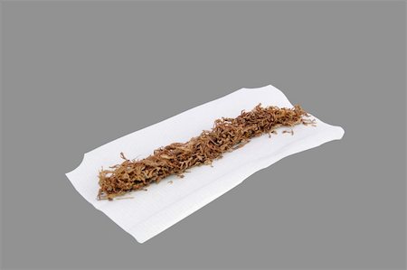 rolling tobacco - Hand rolling tobacco on a cigarette paper isolated on a mid-grey background Photographie de stock - Aubaine LD & Abonnement, Code: 400-05321813