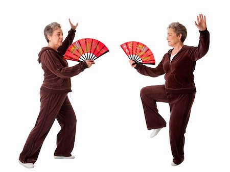 Beautiful Senior woman doing Tai Chi exercise with red dragon fan to keep her joints flexible, isolated. Photographie de stock - Aubaine LD & Abonnement, Code: 400-05322234