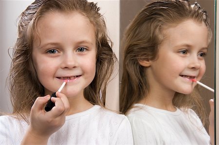 Little girl with lipstick at mirror Foto de stock - Super Valor sin royalties y Suscripción, Código: 400-05322637