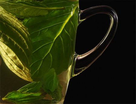 simsearch:400-06554630,k - Fresh mint tea out of mint leaves in a glass cup photographed on black (Selective Focus, Focus on the handle of the glass) Stock Photo - Budget Royalty-Free & Subscription, Code: 400-05322775