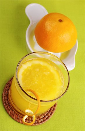 drink coaster - Fresh orange juice with orange slice in glass and squeezer in background on green table mat (Selective Focus) Stock Photo - Budget Royalty-Free & Subscription, Code: 400-05323886