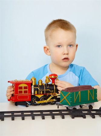 simsearch:400-05292821,k - Little boy playing with a plastic toy locomotive on blue Stock Photo - Budget Royalty-Free & Subscription, Code: 400-05334261