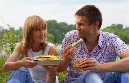 Young happy couple eating together outdoors. Young loving couple having a picnic outdoors Foto de stock - Super Valor sin royalties y Suscripción, Código: 400-05334397