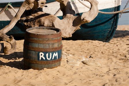 Wooden barrel of rum near striped ship on the sand seashore Fotografie stock - Microstock e Abbonamento, Codice: 400-05334528