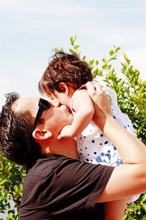 surprised toddler girl - father in early thirties gives his son a kiss on the cheek in the park Stock Photo - Budget Royalty-Free & Subscription, Code: 400-05334907